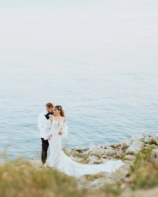 Bride and groom embracing on a rocky Adriatic coastline — wedding photography by Nemanja Potkonjak